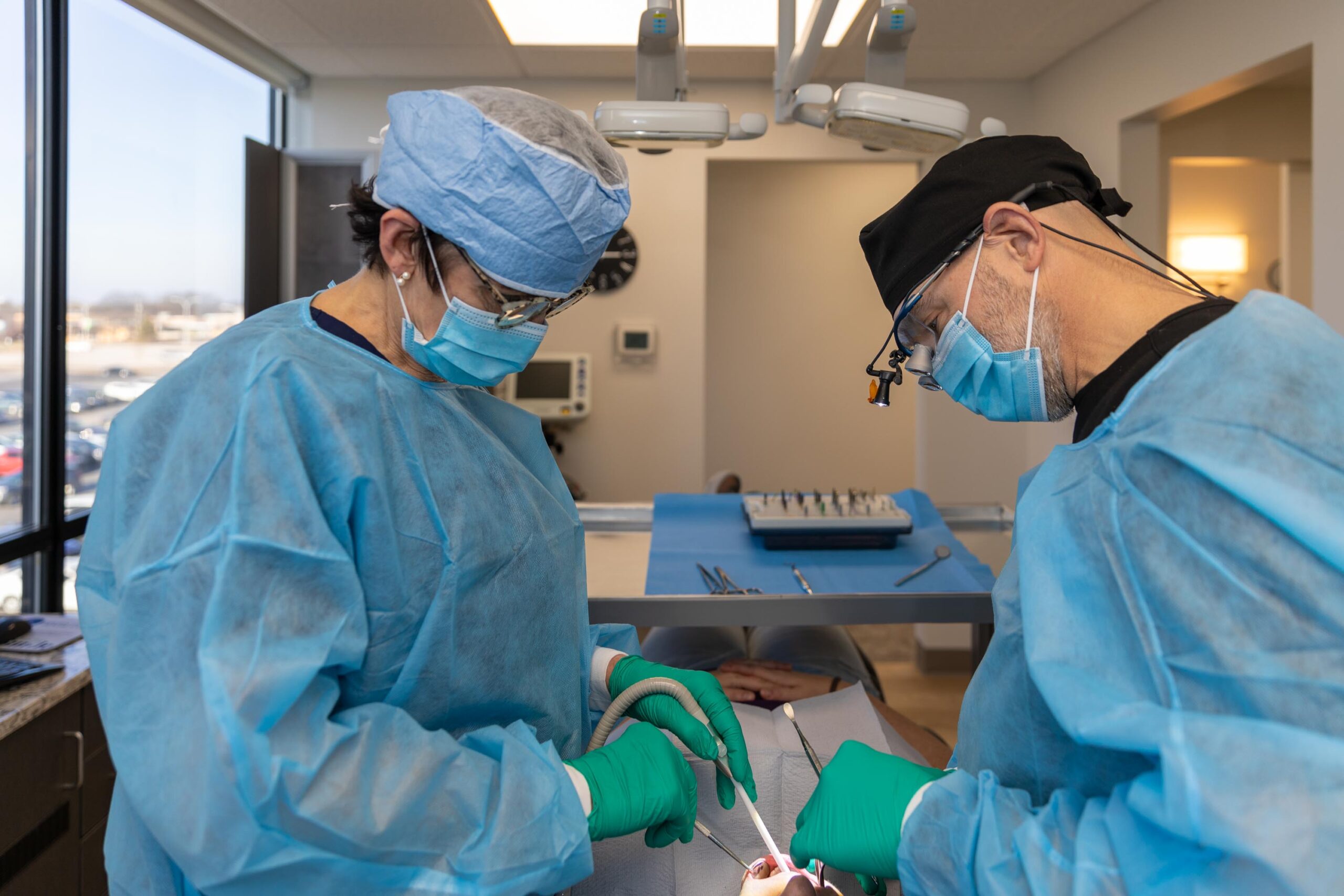Dr. Fetsch and his dental assistant performing a wisdom tooth removal procedure on a patient.