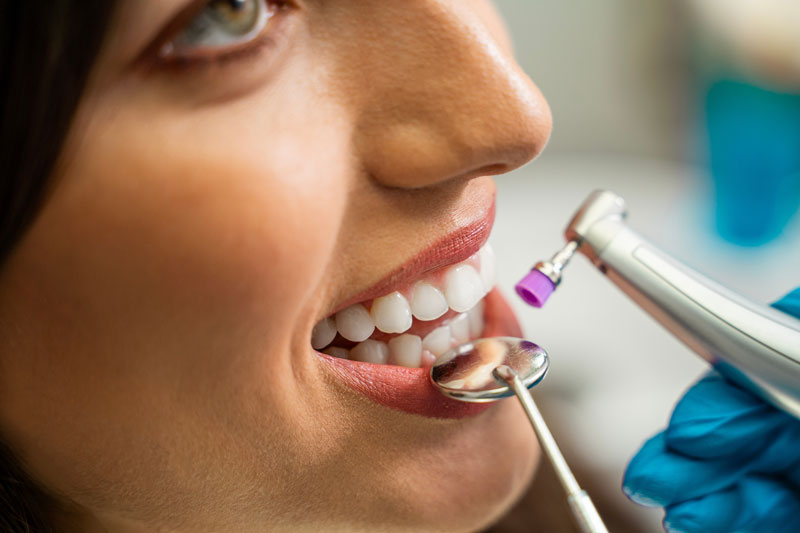 Closeup shot of a women getting a teeth whitening treatment, young woman patient