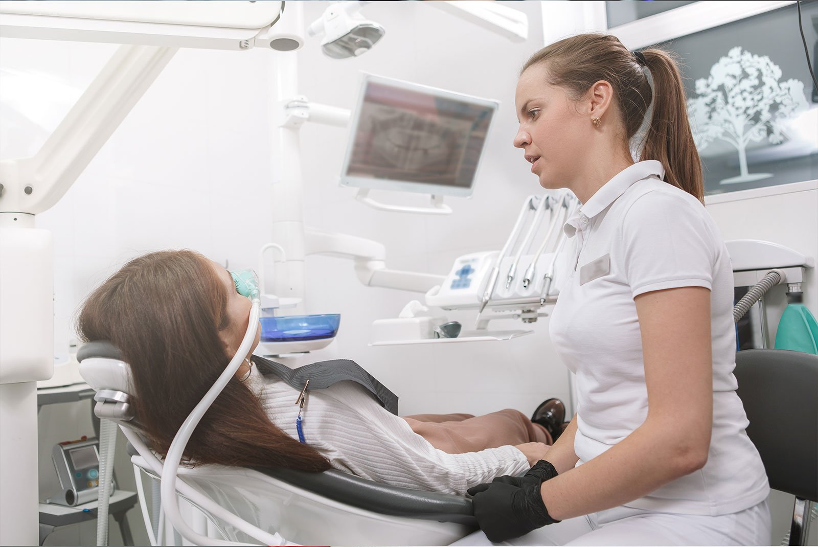 Dentist talking to her patient after putting inhalation sedation